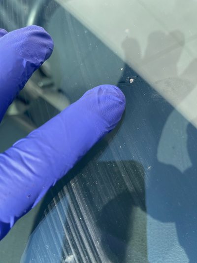 Close-up of a windshield rock chip that needs repair before it spreads